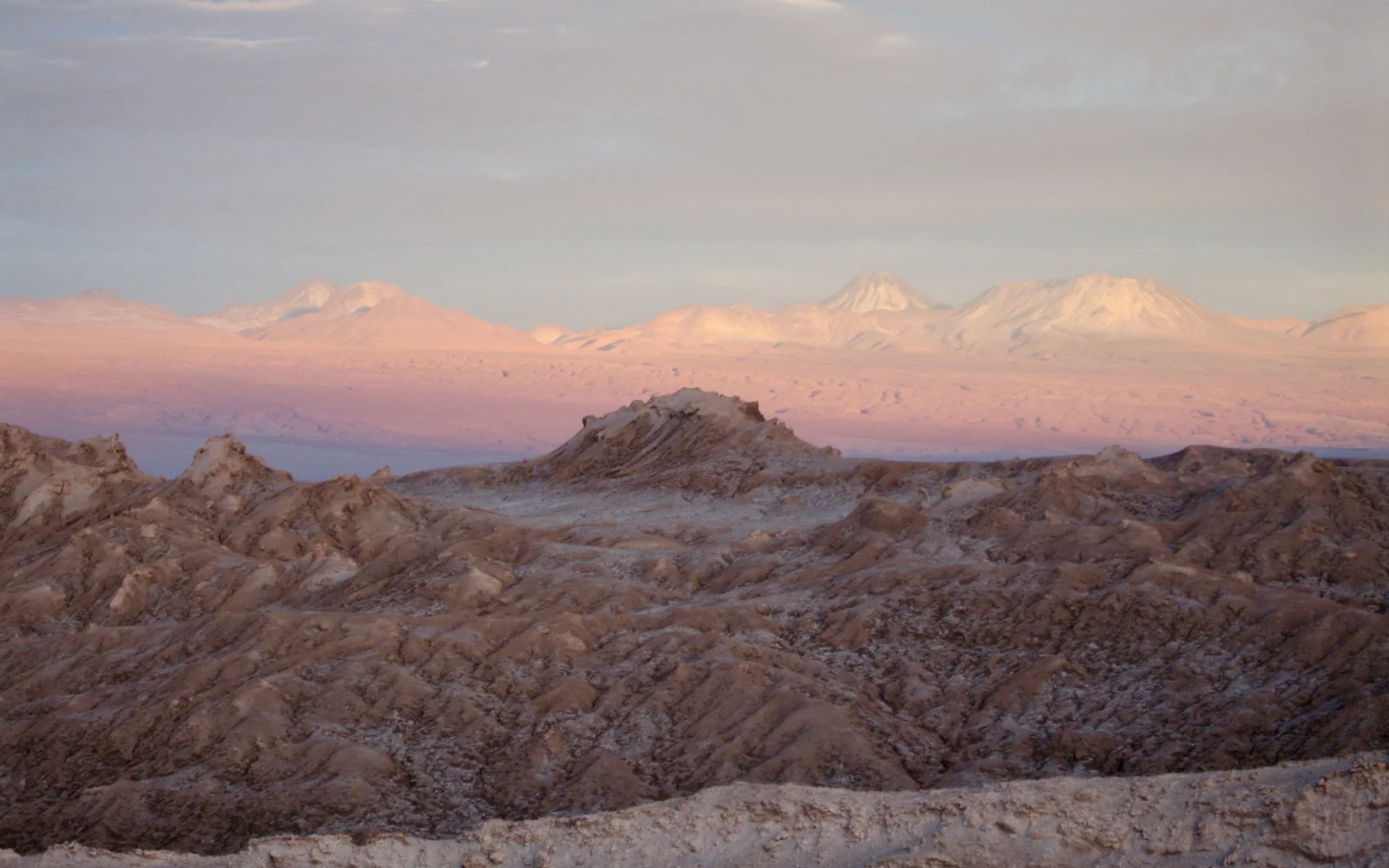 Sonnenuntergang in der Atacama-Wüste mit Andengipfeln am Horizont