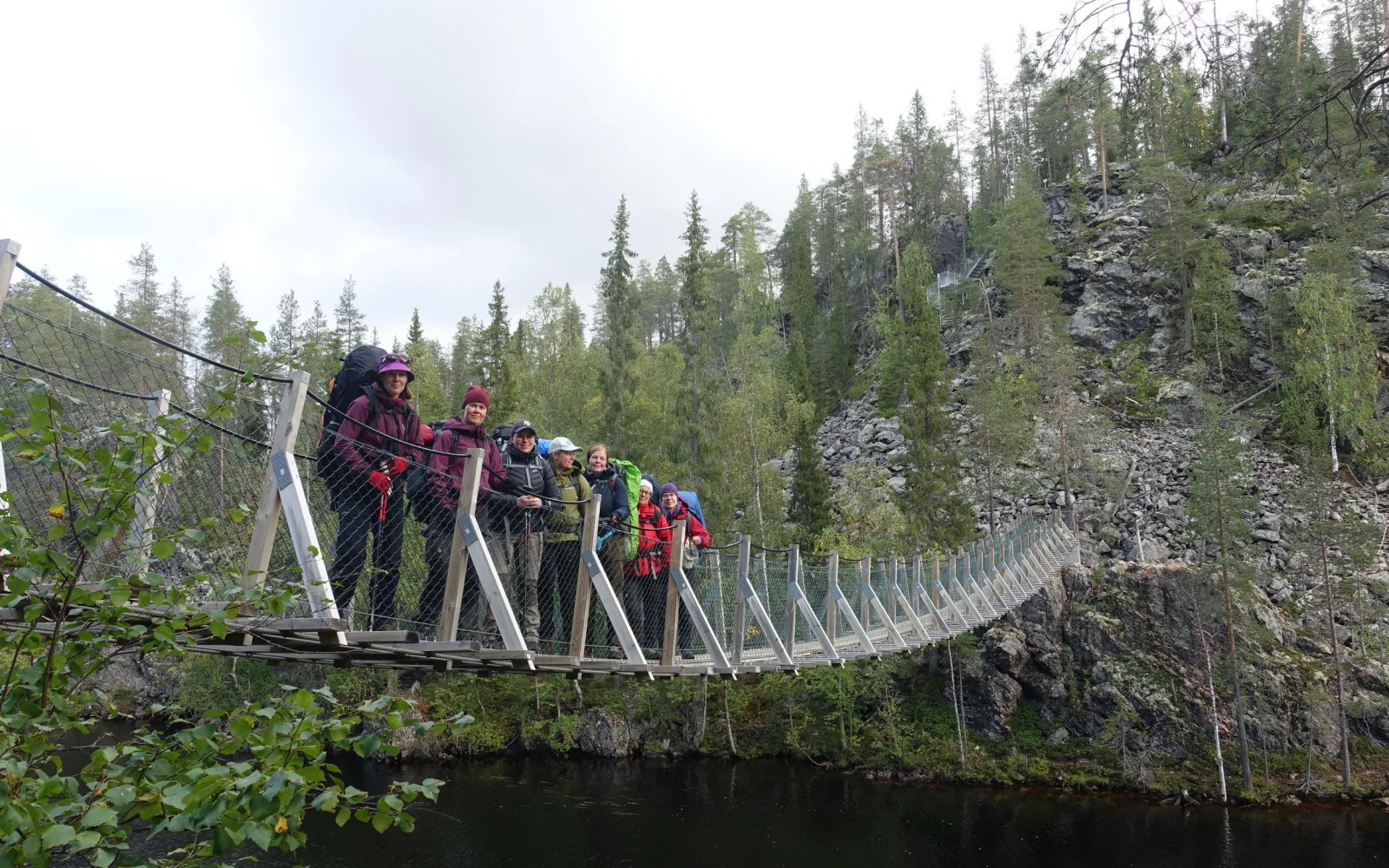 Sie queren eine eindrucksvolle Hängebrücke über den Canyon-See.