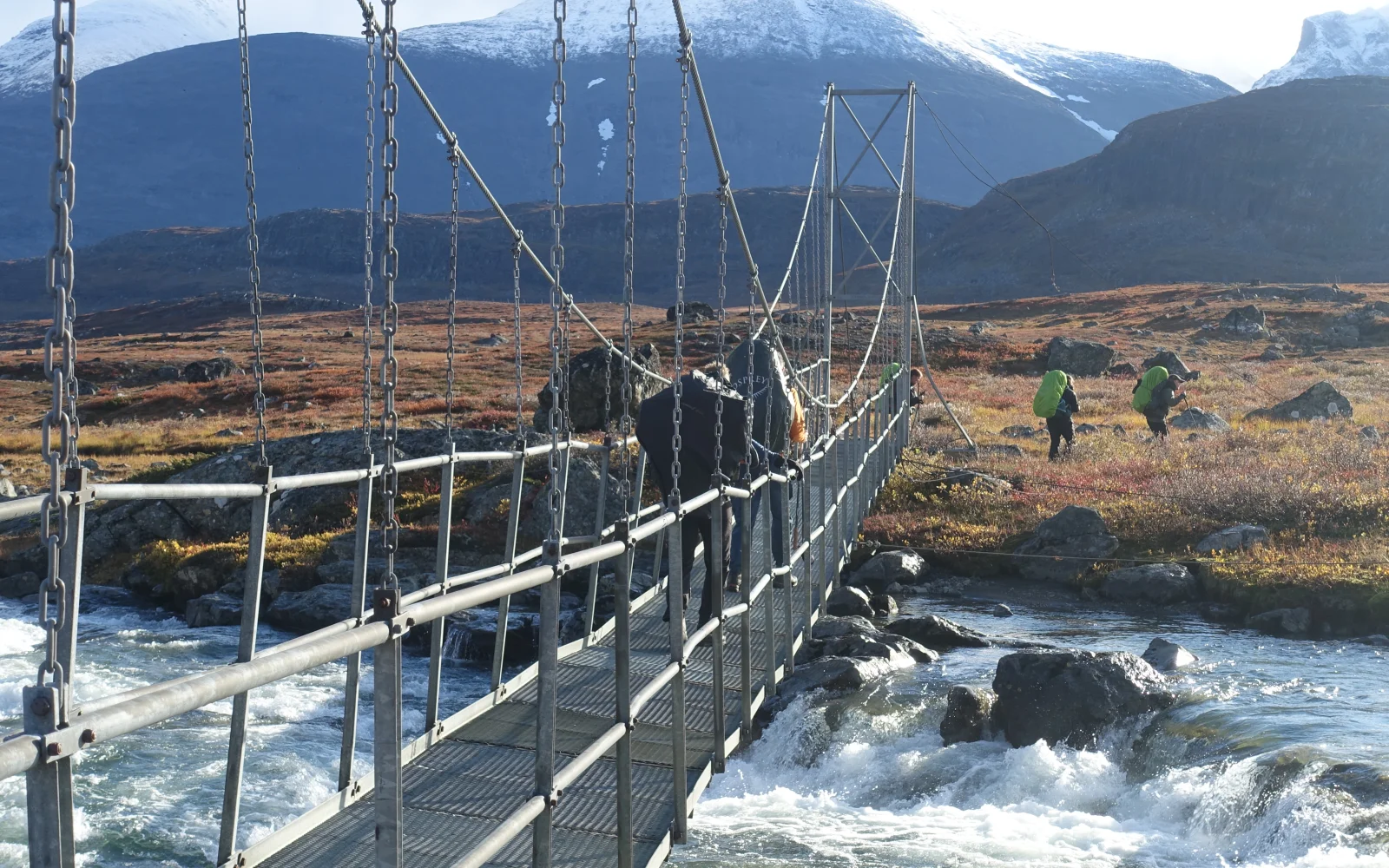 Den Guhkesvakkjahka-Fluss mit seiner starken Strömung queren Sie per Brücke