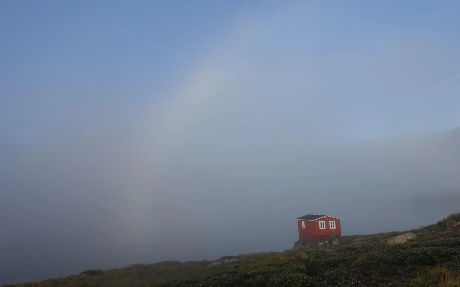 Die rote Innajuattoq-Hütte liegt malerisch am Seeufer.